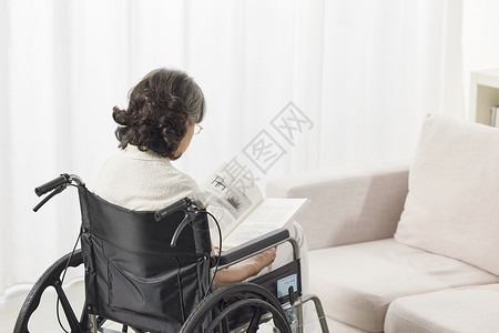 残疾老人独自坐在轮椅上的背影背景