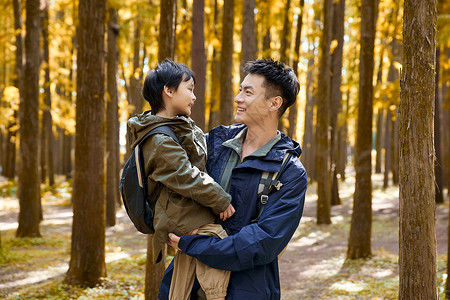树林里抱着孩子的父亲形象高清图片