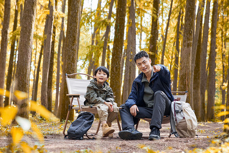 宿营坐在树林里休息的父子形象背景