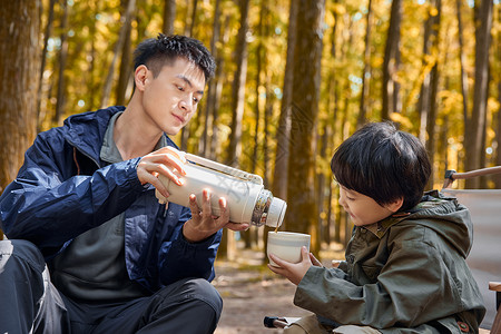 拿着水壶男孩父亲给孩子倒水背景