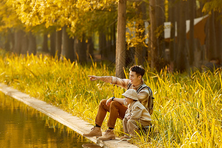 看月兔的男孩坐在湖边看日落风景的父子背景