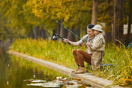 户外体验秋游在湖边钓鱼的父子俩背景