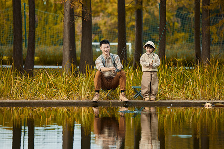 坐在河边认真钓鱼的父子俩图片