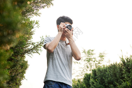 男生拍照户外手拿照相机的男性背景