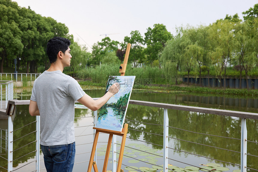 户外画画写生的男性图片