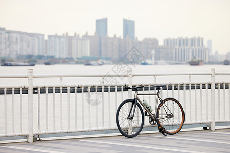 桥围栏停在江边栏杆上的自行车背景