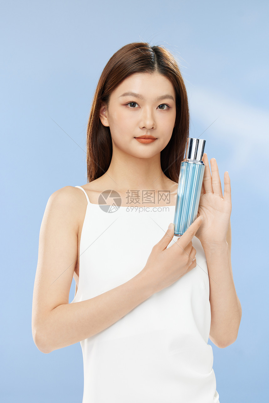 手持化妆品的年轻美女图片