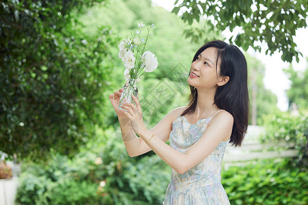 抱着鲜花户外女生抱着玻璃花瓶背景