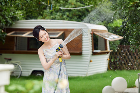 浇花的女孩夏日户外纳凉享受的女性背景