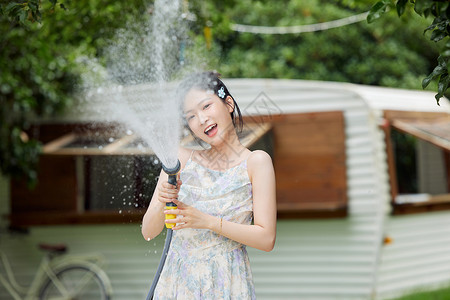 户外女生手拿水枪玩耍背景图片