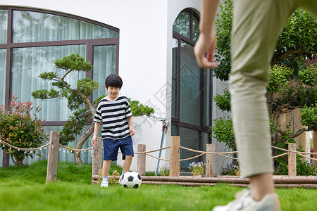 花园里踢足球的父子图片