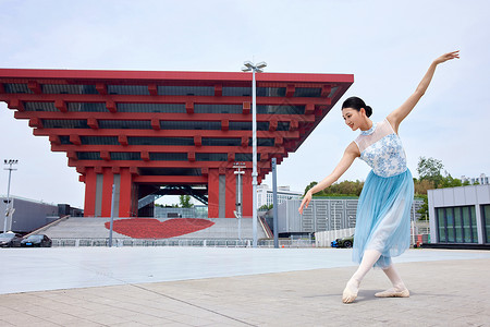 广场舞蹈红色建筑物前翩翩起舞的女性背景