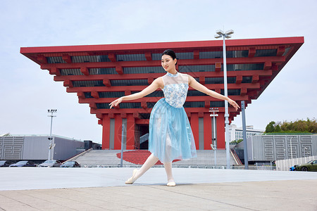 广场舞蹈在红色建筑物前舞蹈的女性背景