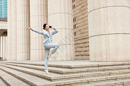 边接电话边跳芭蕾的商务女性图片