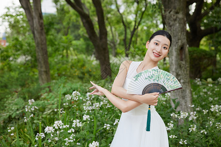 手绘植物扇子公园里舞扇的白裙女子背景