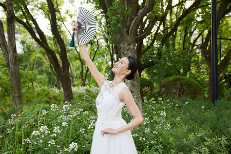 花朵扇子中国风舞动扇子的白裙少女背景