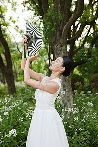 花朵扇子舞动扇子的白裙舞者背景