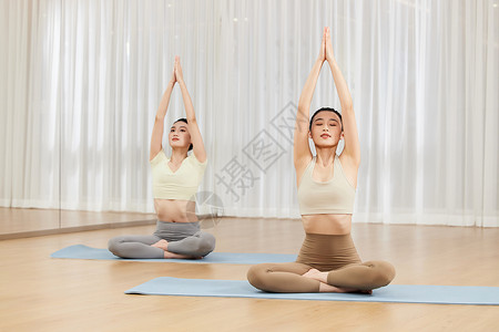 进行瑜伽锻炼拉伸的两位女生图片