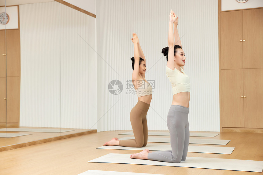 练习瑜伽伸展动作的两位女性图片
