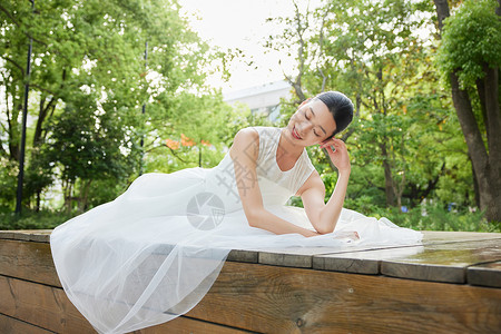 坐在木椅上的白裙舞蹈女子图片