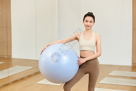 运动女生抱着瑜伽球图片