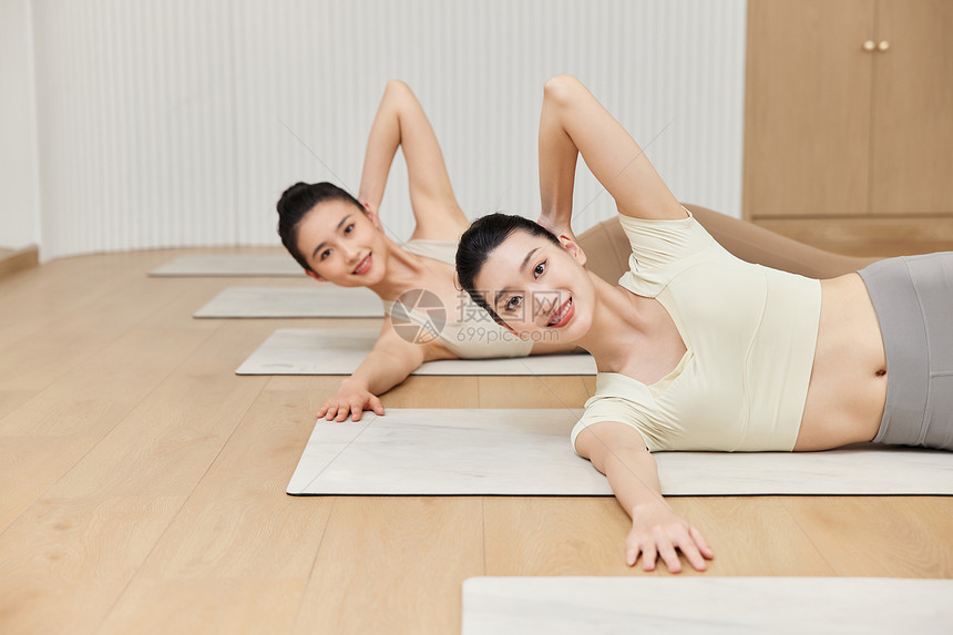 两个女生在瑜伽垫上做瑜伽图片