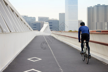 右侧人素材靠道路右侧骑行的男性背影背景