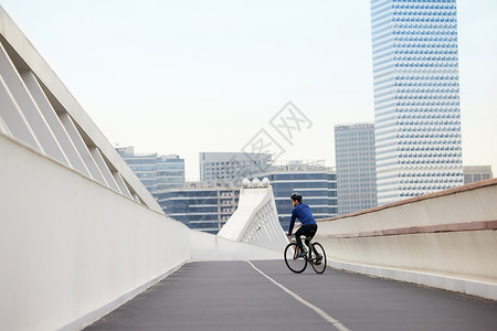 靠道路右侧骑行的男性背景图片