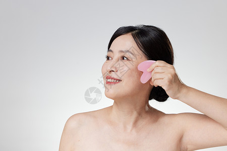 面部仪器女性进行面部刮痧背景