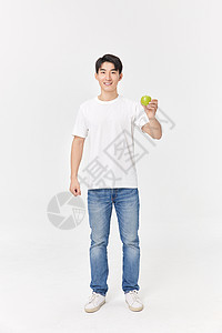 健身男性手拿青苹果背景图片