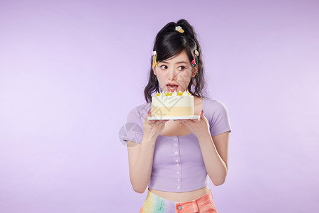 大口吃生日蛋糕的女性图片