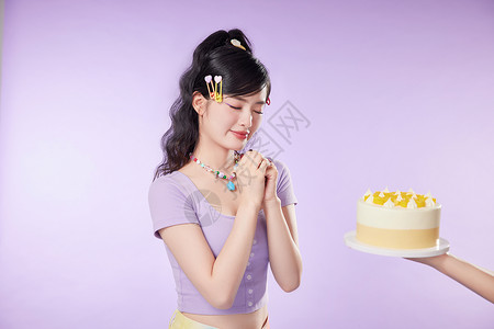 可爱女生对着蛋糕许愿背景图片