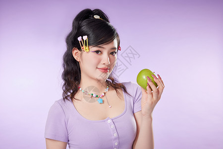 彩色背景可爱女生手拿苹果图片