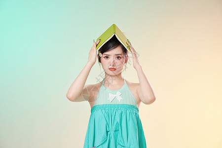 头顶着书的学生用头顶着书的女孩背景