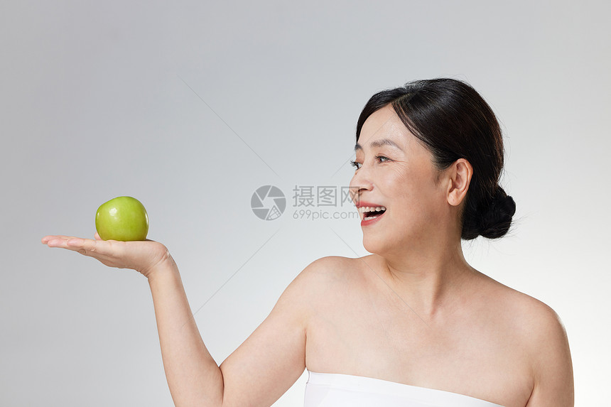 展示青苹果的中年女性图片