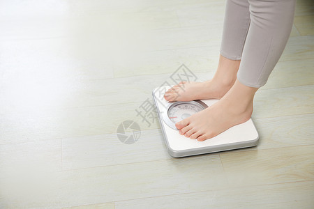女性站在体重秤上背景图片