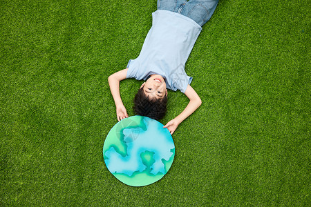 儿童躺在草坪上手举地球图片