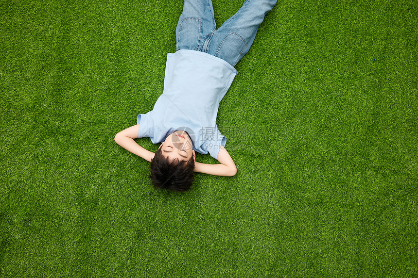 小男孩躺在草坪上休息图片