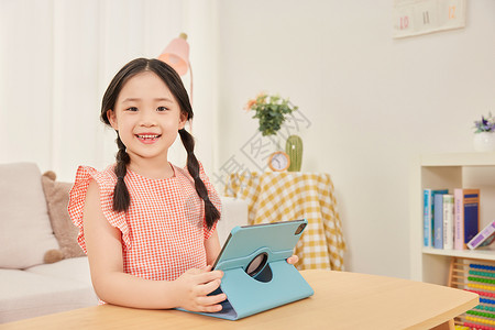 在家里看书的女孩小女孩在家里看平板电脑形象背景