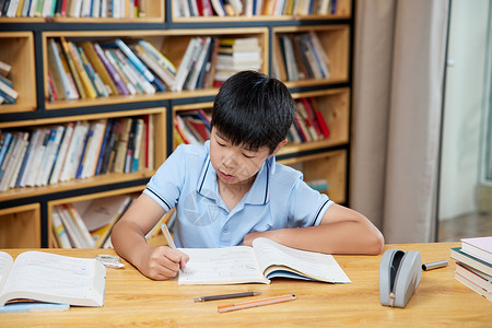 男孩认真学习书桌前认真学习的男孩背景