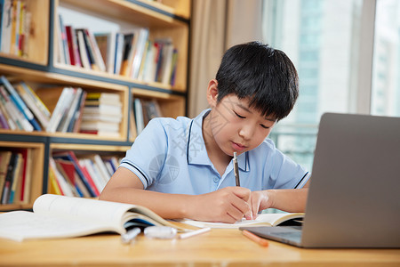 小学生在线学习电脑前认真学习的男孩背景