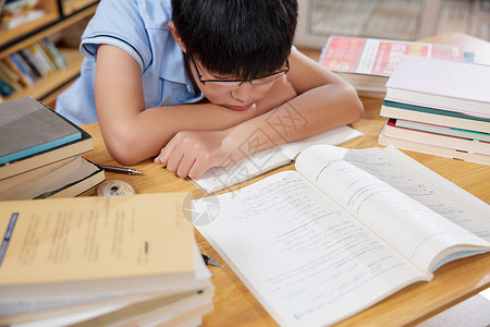 孩子学习压力大学习压力大疲惫睡着的男孩背景