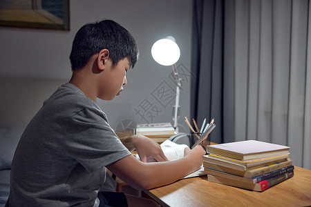 台灯下写作业的男孩图片