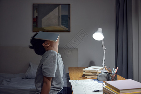窗头台灯不愿意写作业的男孩背景