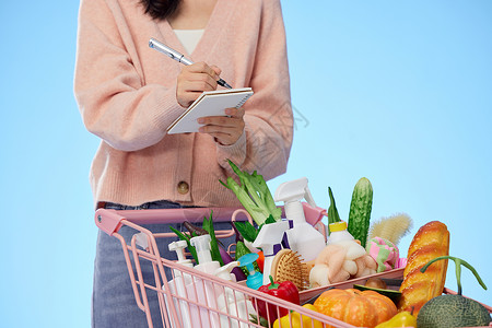 购物消费清单看着清单购物的女性背景
