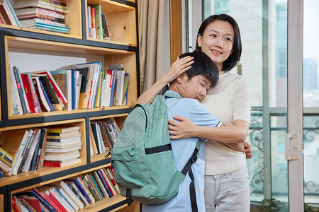 抱着妈妈的男孩背着书包的孩子紧紧地抱着妈妈背景