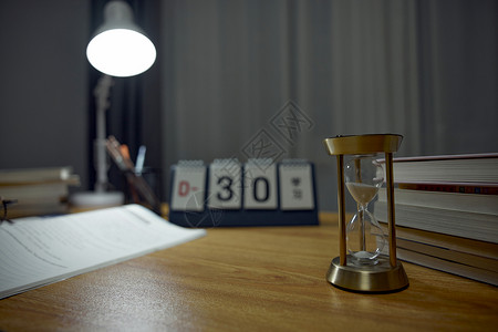 考研倒计时桌面日历书桌上的倒计时沙漏特写背景