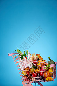 装满食物的粉色购物车背景图片
