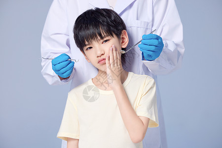医生给牙疼的男孩孩治疗牙齿图片