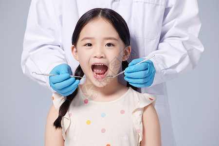 献花给牙齿医生给小女孩治疗牙齿背景